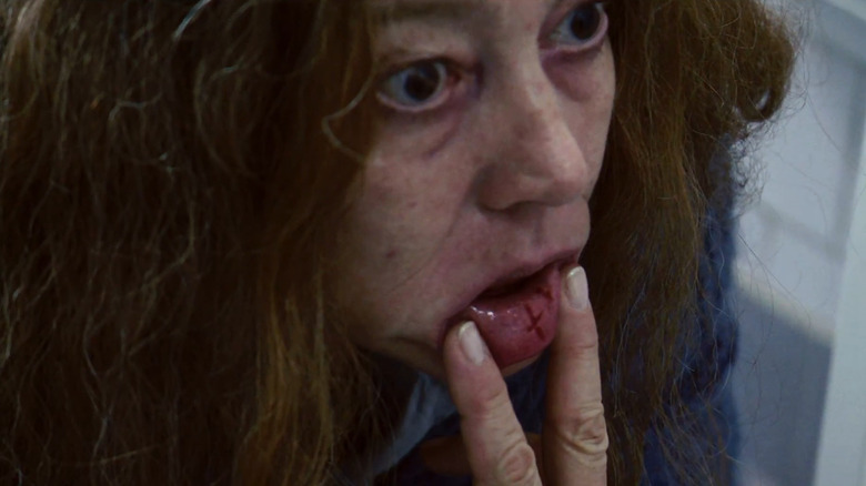 A possessed woman displays an upside-down cross on her inner lip in "The Devil Inside" (2012)