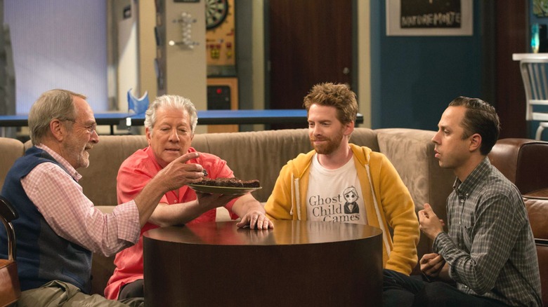 Crawford, David, Eli, and Warner sitting around a table eating brownies in "Dads"