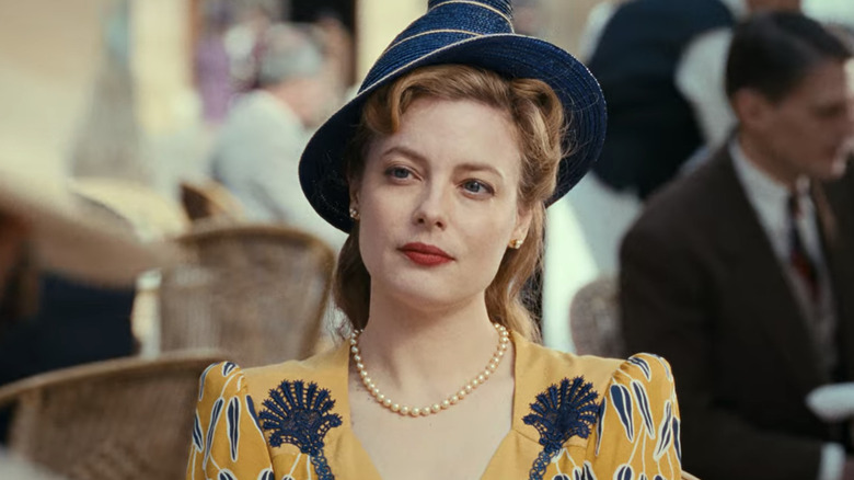 Mary Jayne Gold wearing a yellow dress, blue hat, and bright red lipstick