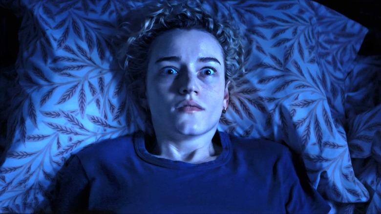 Justine lies in bed looking shocked in "Weapons" (2025)