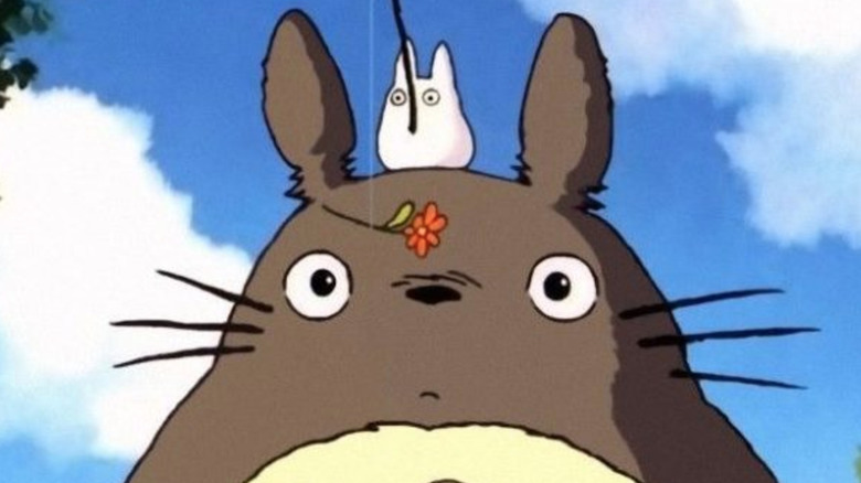 Totoro, with a tiny Totoro on his head with a flower on fishing rod
