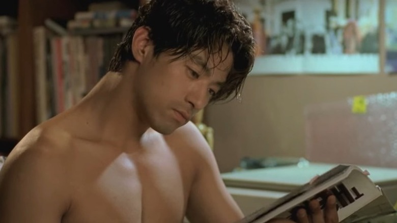 Il-beom reading a magazine with no shirt on in Happy End (1999)