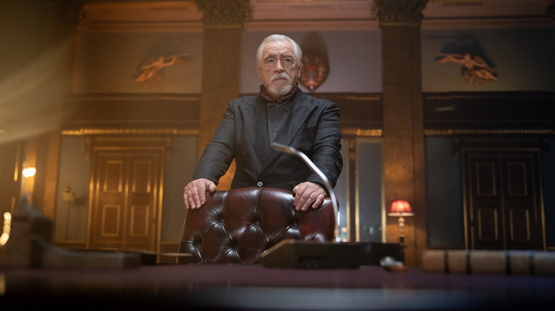 Brian Cox standing behind desk 