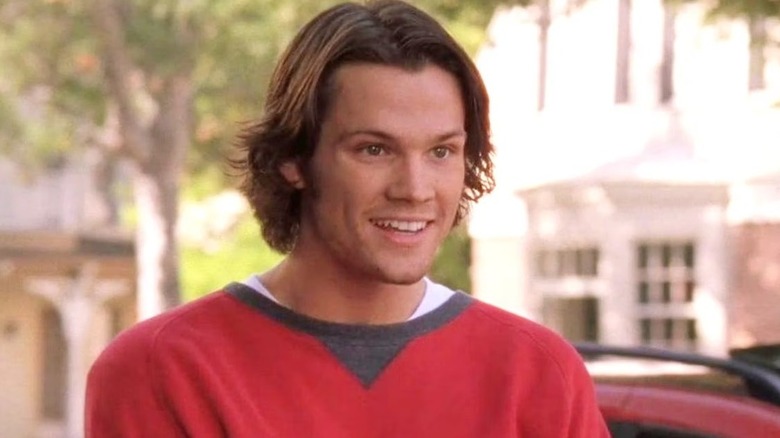 Dean with long hair and a red sweater smiling on Gilmore Girls