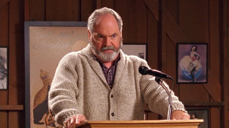 Taylor leading a town meeting and glaring on Gilmore Girls