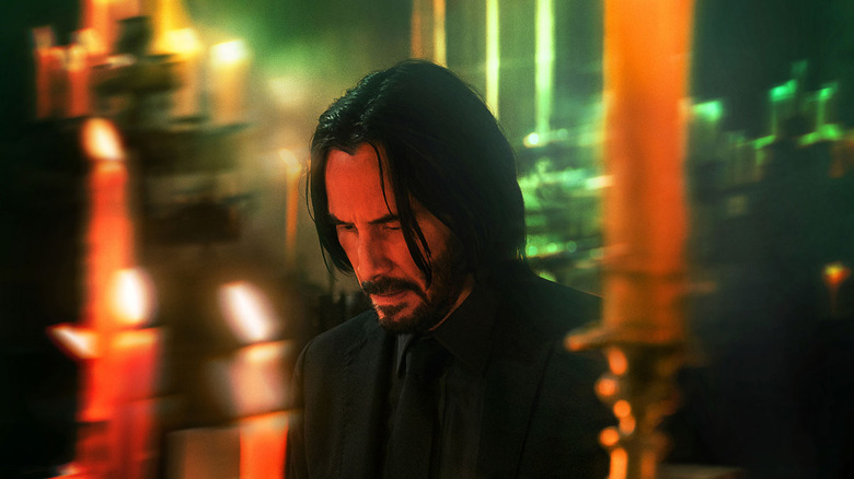 John Wick in front of red lights