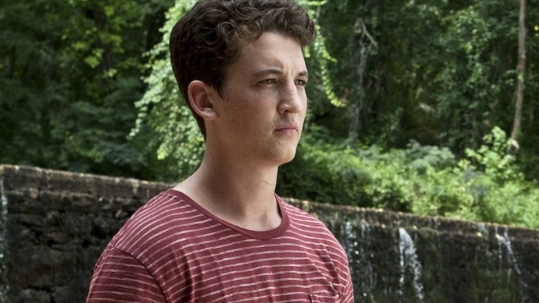 Sutter Keely in a striped shirt in the woods