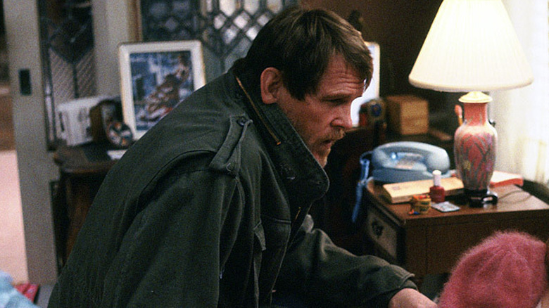 Nolte sits on a woman's bed