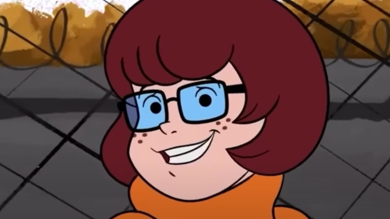 Velma smiles nervously