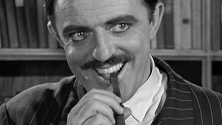 Smiling Gomez Addams with a cigar in his mouth