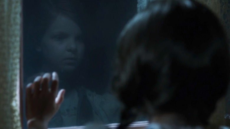 Little girl stands at window