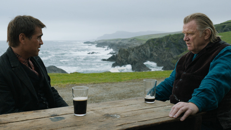 Colin Farrell and Brendan Gleeson sharing a pint near the shore