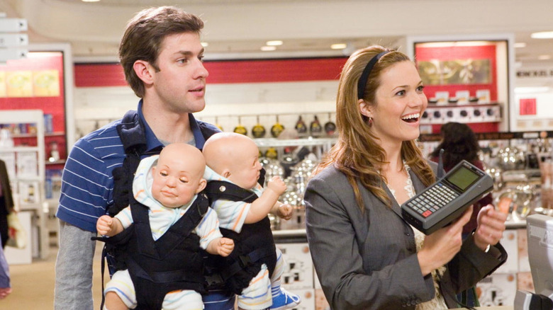 Ben and Sadie swaddling two robot babies in a department store