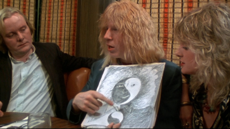 Ian, David, and Jeanine look at a makeup sketch in "This Is Spinal Tap" (1984)