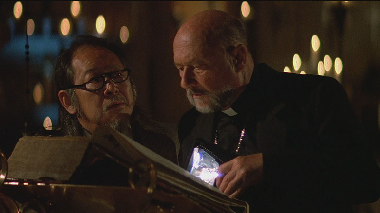Professor Birack and the priest review religious text
