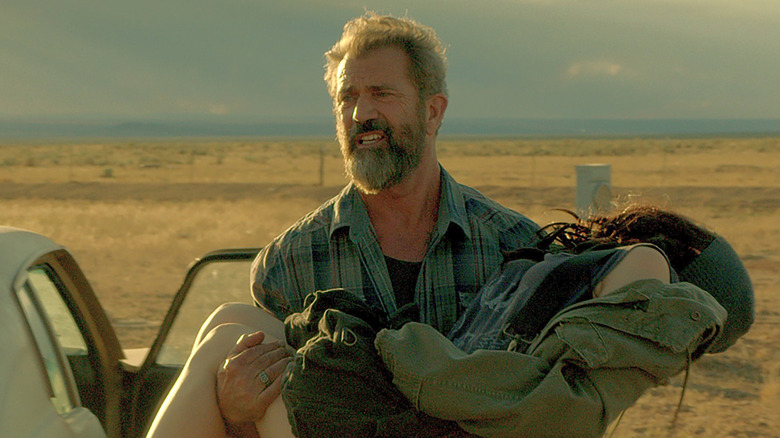 Mel Gibson carrying daughter
