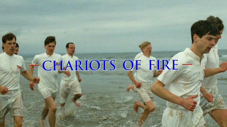 men run on beach with movie title on screen