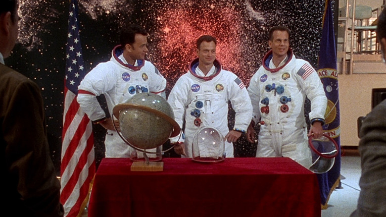 Astronauts Jim Lovell (Tom Hanks), Ken Mattingly (Gary Sinise), and Fred Haise (Bill Paxton) appearing before the press in anticipation of their space launch