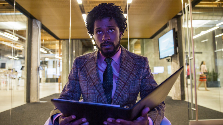 Cash holding a binder looking up