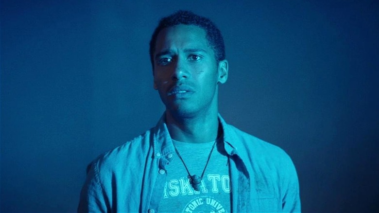 Ward Phillips looking nervous bathed in blue light in Color Out of Space