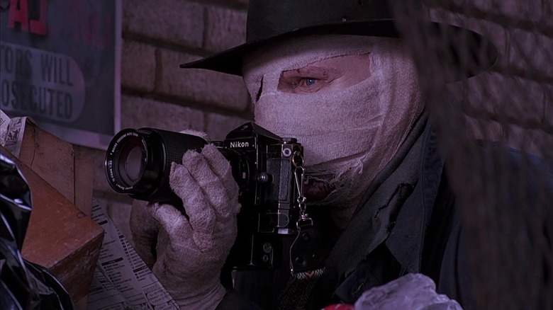 Darkman holding camera