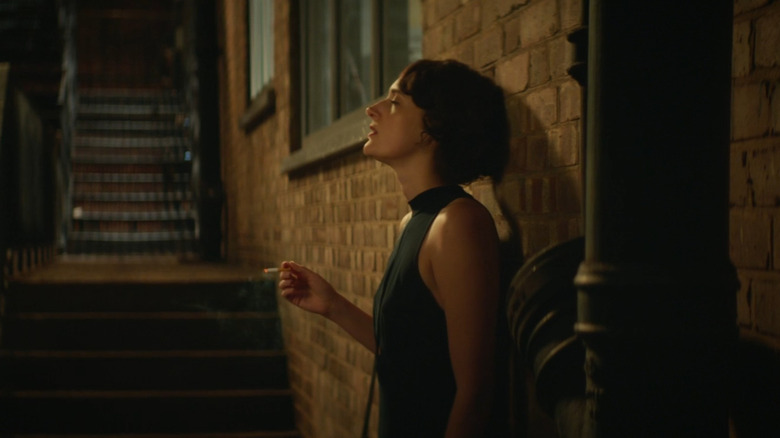 Fleabag smokes a cigarette