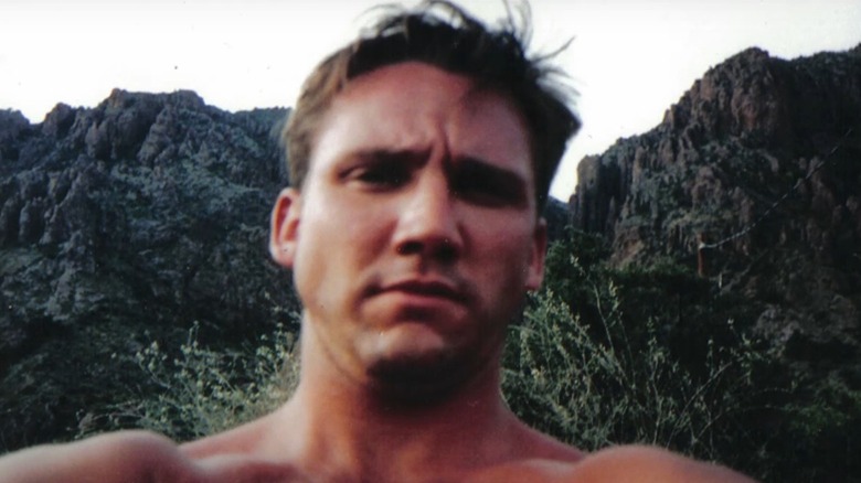 Travis Davis in a selfie taken in front of a mountain range