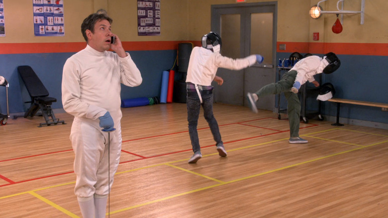 Barry on phone while Raj and Howard fence
