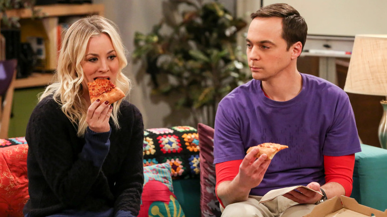 Penny eating pizza while Sheldon watches on The Big Bang Theory