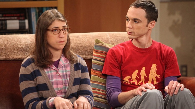 Sheldon looks surprised at a guilty-looking Amy