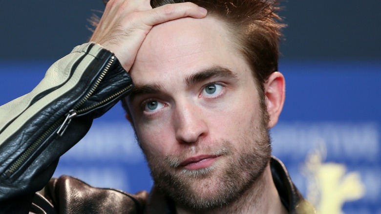 Robert Pattinson light stubble hand on head