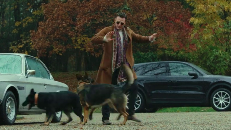 Ransom Drysdale walks past barking dogs in "Knives Out" (2019)