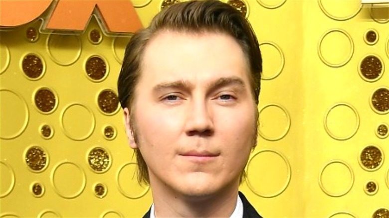 Paul Dano standing by yellow wall