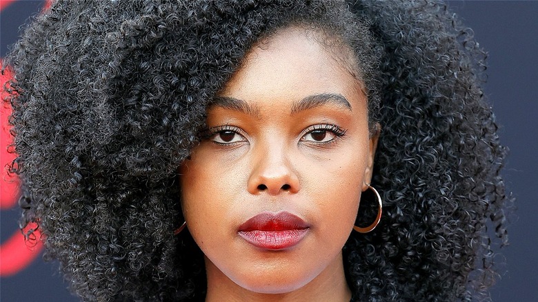 Monique Green standing in front of a black-and-red background