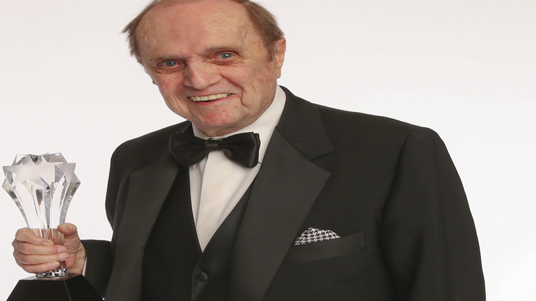 Bob Newhart smiles holding a trophy