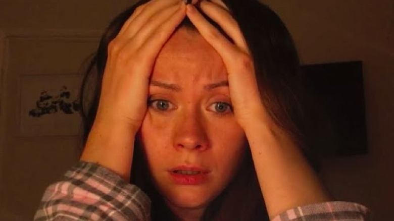 Terrified woman clutches face