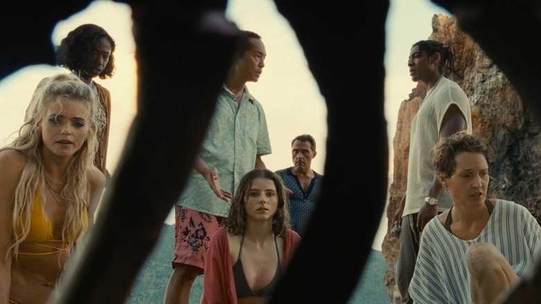 The characters of Old seen through a skeleton on the beach