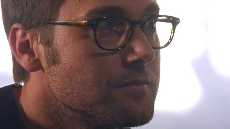 Tom Keen wearing glasses and looking intrigued