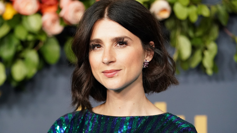 Aya Cash stands by flowers