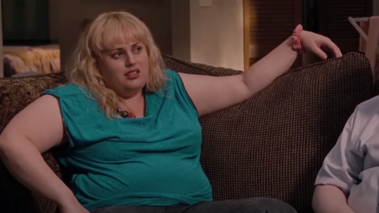 Bridesmaids Brynn in turquoise top sits on the couch