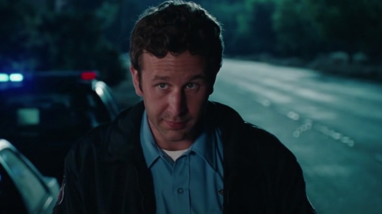 Bridesmaids Chris O'Dowd looks up while in a police uniform