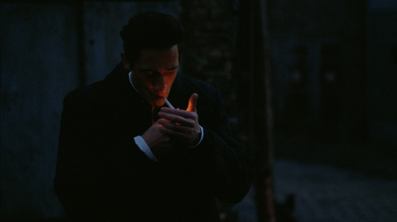 Laszlo lights cigarette