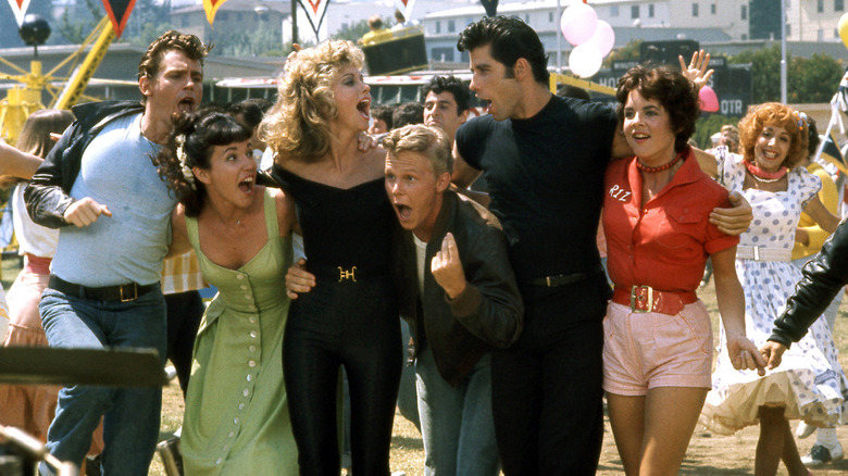 The cast of Grease singing and dancing