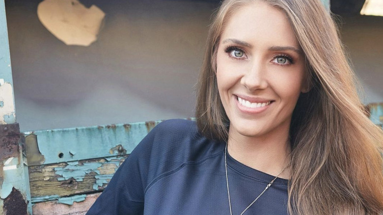 Jenna smiling and sitting on a bench