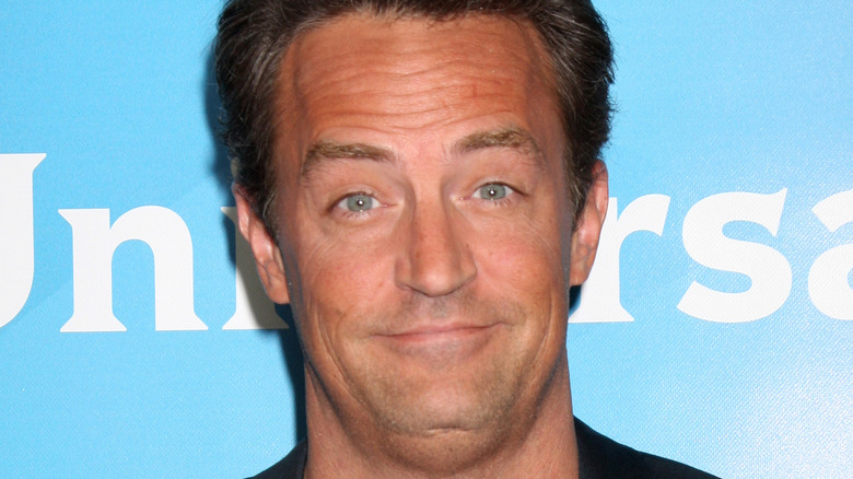 Matthew Perry grinning shrugging