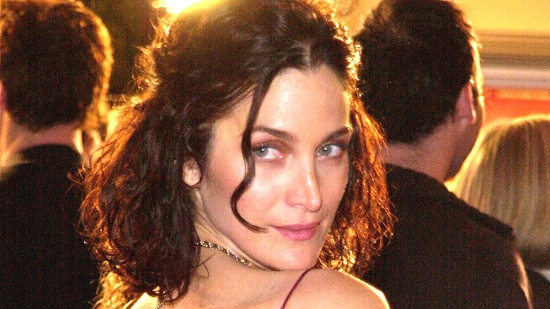 Carrie-Anne Moss looking over shoulder