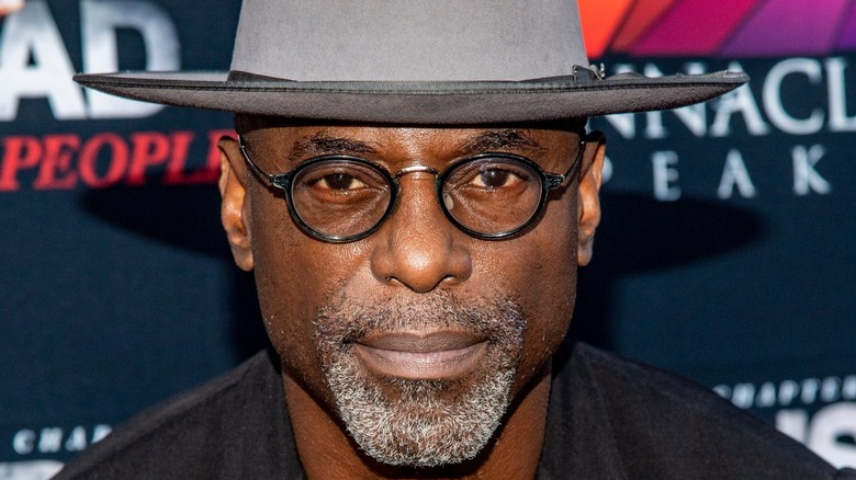 Isaiah Washington smiling against a blue backdrop