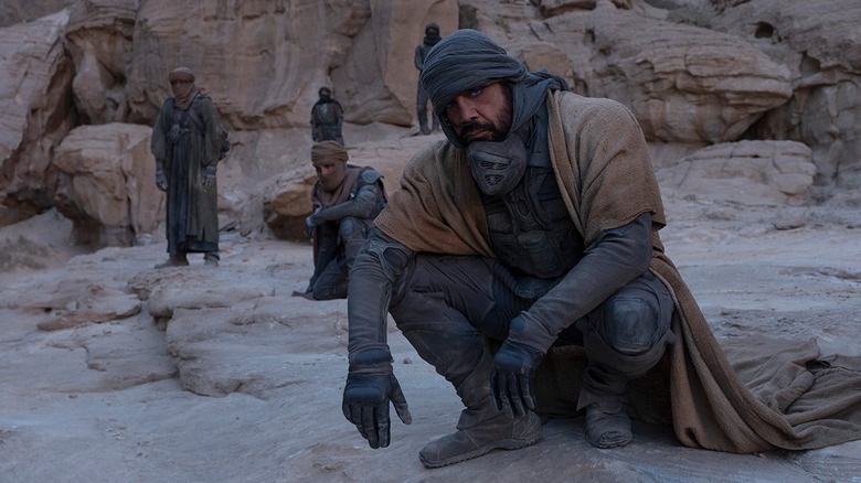 Stilgar and Fremen crouch in fading light on rocks in "Dune: Part One" (2021)