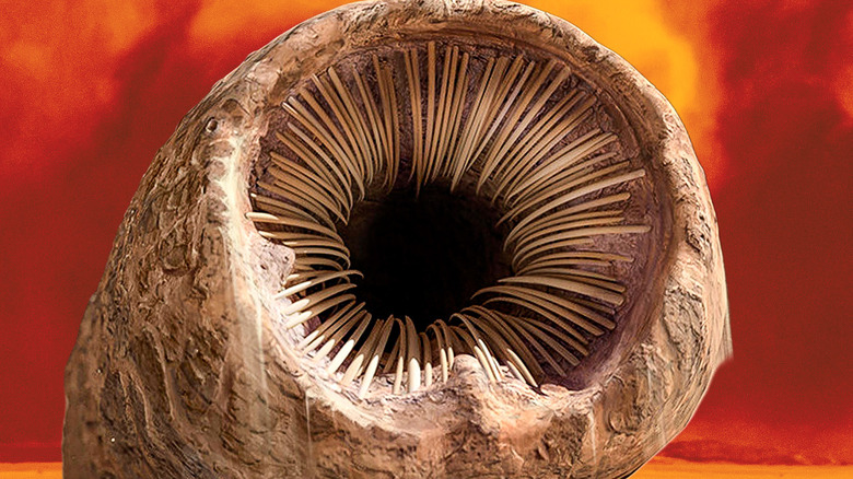 A sandworm bearing its teeth against a red, stormy background