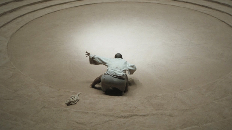A person summons a young sandworm in "Dune: Part Two" (2024)